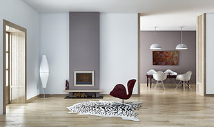gray and white fireplace with red armchair on white and black animal fur rug in living room