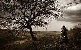 woman kneeling near black tree