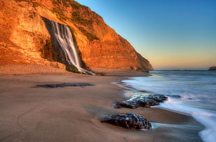 photography of sea waves near brown rock mountain, california HD wallpaper