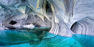 gray rock formation in water, lake, cave, Chile, erosion