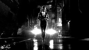 gray scale photography of woman standing near lights
