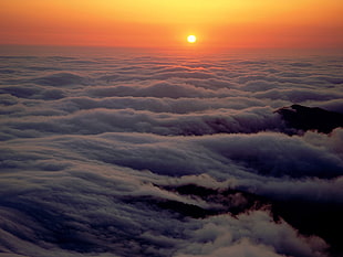 aerial photo of foggy mountain with orange sky HD wallpaper