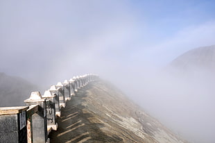 photo of concrete fence beside rocky mountain, tengger, semeru