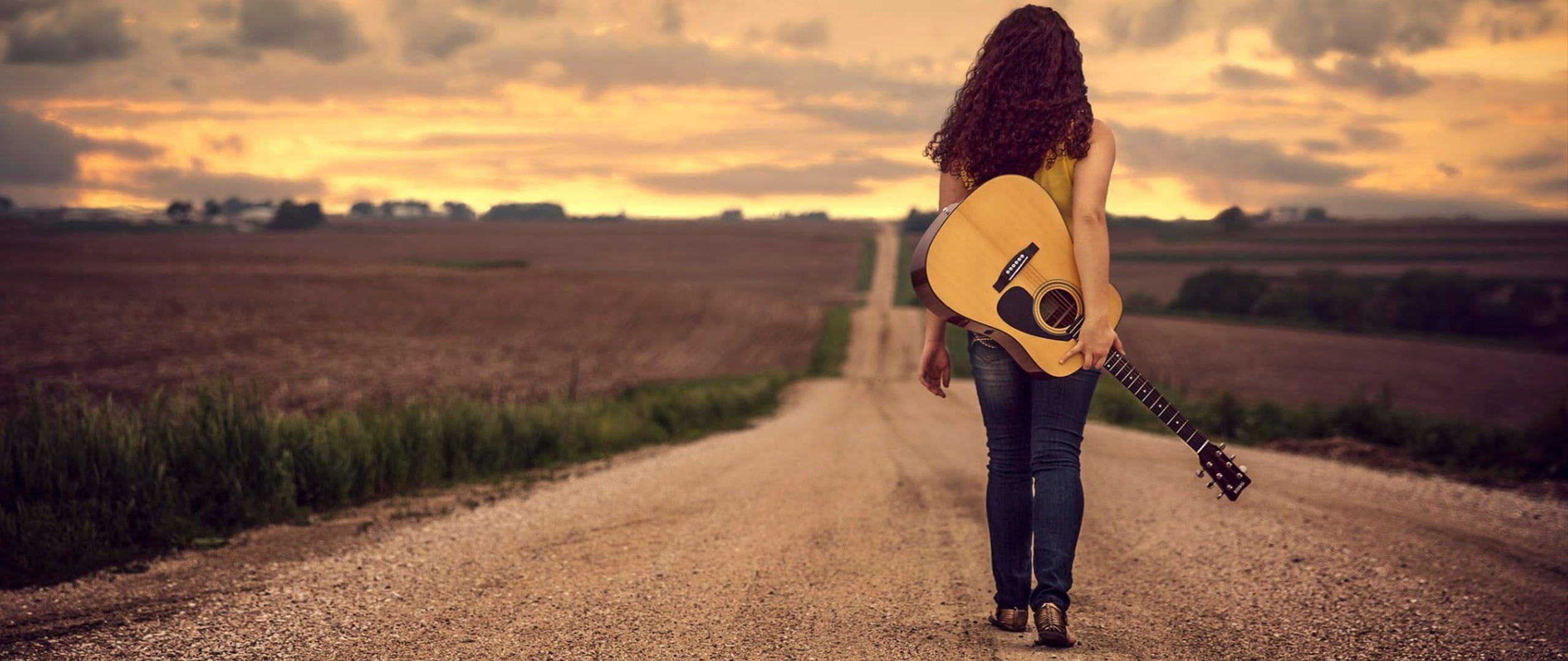 Песни в дорогу 2024. Девушка на дороге. Девушка с гитарой. Гитара на спине. Девушка с гитарой идет.