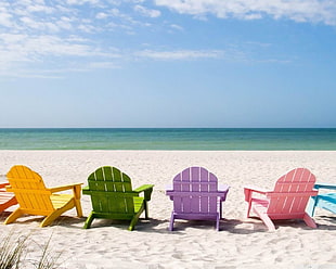 yellow, green, purple, and pink wooden adirondack chairs, deck chairs, sand, beach