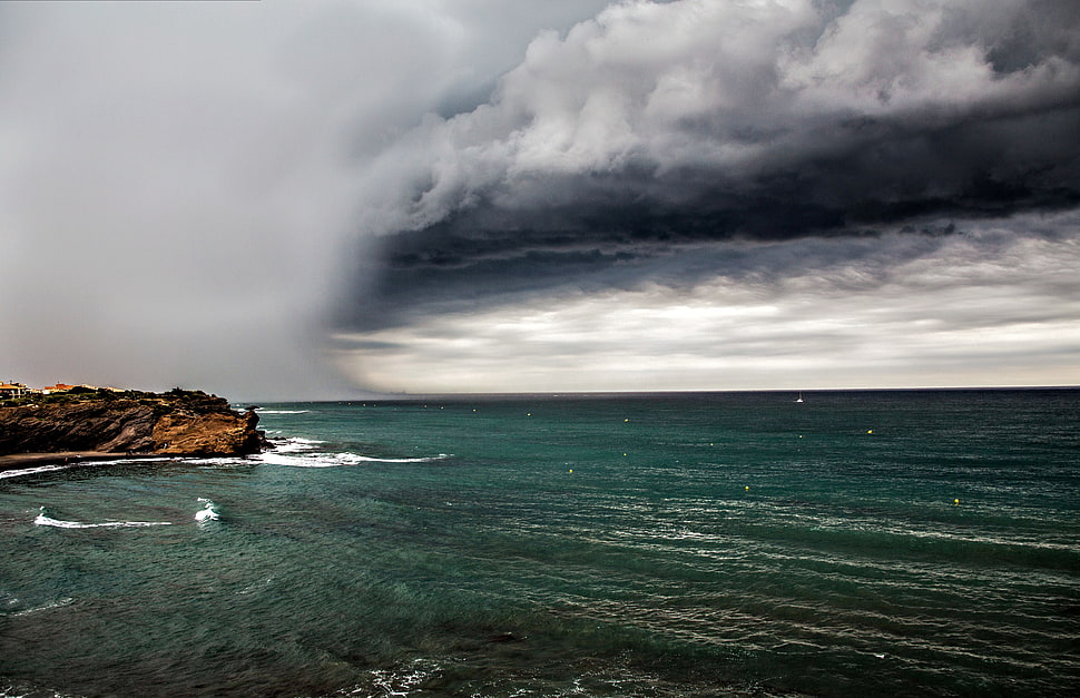 brown rock sea shore during storm HD wallpaper