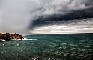 brown rock sea shore during storm
