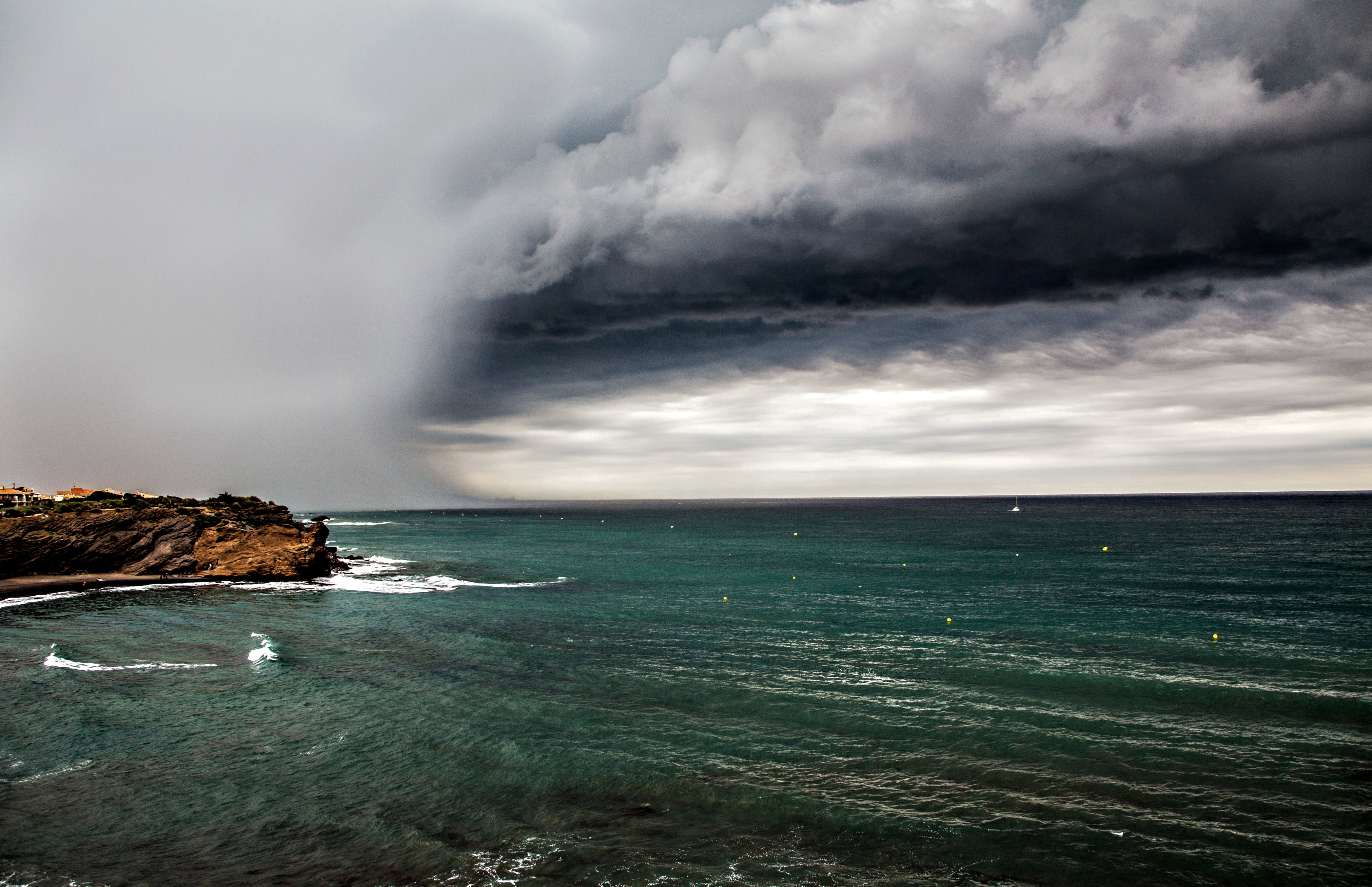 brown rock sea shore during storm