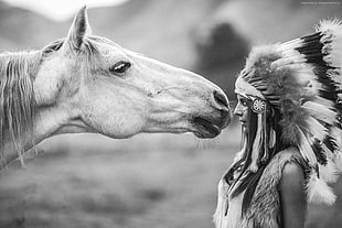 grayscale photo of female Native American facing horse