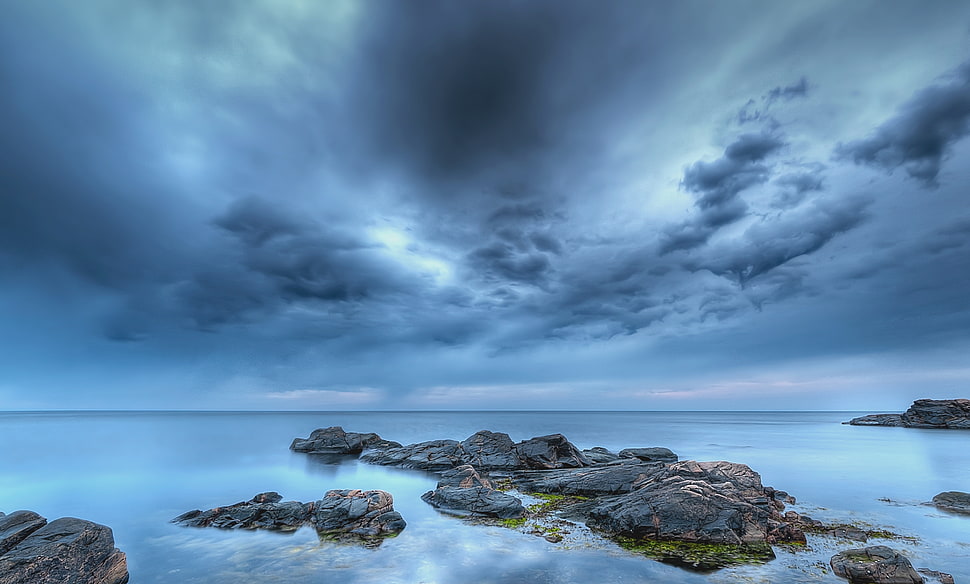 view of beach, rocks and cloudy sky during daytime HD wallpaper