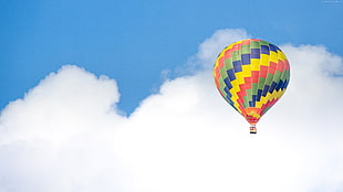 multicolored hot air balloon flew near white and blue sky