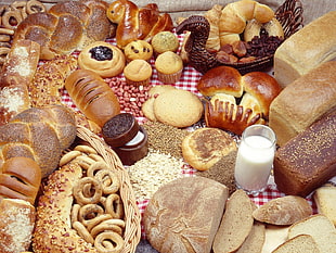 variety of bread with drinking glass filled white liquid