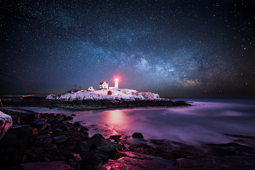 white concrete lighthouse surrounded by body of water under starry night HD wallpaper