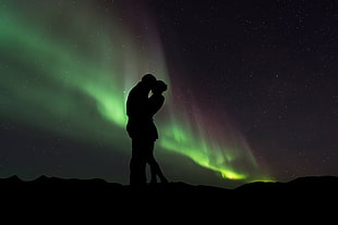 silhouette photo of kissing man and woman at night with green light HD wallpaper