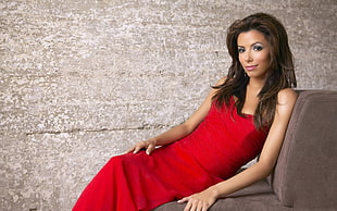 women's red sweetheart neckline sleeveless dress leaning on suede sofa HD wallpaper