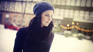 woman wearing grey beanie taking photo in shallow focus photography with mild vignette
