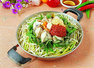 noodles with dumplings and vegetable leaf on cooking pot