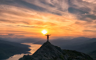 photo of man on top of mountain during sunset