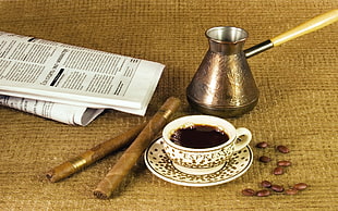 two brown tabaccoo sticks beside white ceramic cup