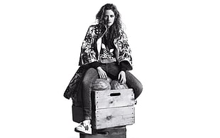 grayscale photo of woman wearing Adidas jacket sitting on watermelon on crate