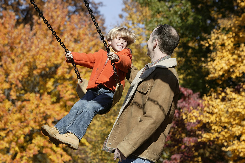 father helping his child playing outdoor swing chair HD wallpaper