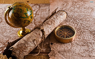 gold framed globe on paper map