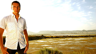 man standing in open field during daytime