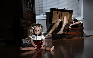 female doll on brown hardwood floor near woman in trunk focus photography
