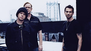 three men in black shirt standing