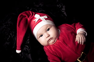 infant wearing santa hat with long-sleeved top