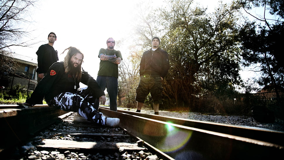 closeup photography of music band standing on train railways HD wallpaper