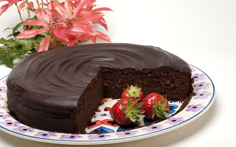 sliced chocolate cake and three strawberries on round white and pink floral plate HD wallpaper