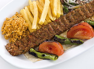 grilled meat with fries, sliced tomatoes and vegetables on plate