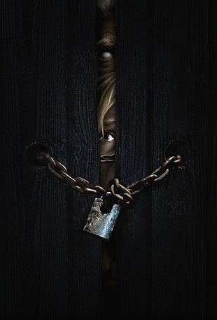 person behind chain locked door