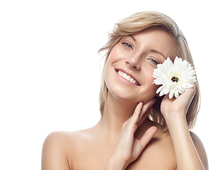 woman holding white Daisy flower smiling