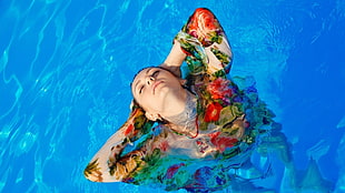 woman in multicolored floral dress on water