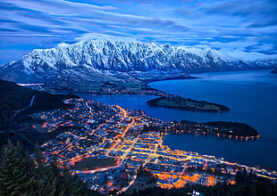 aerial view of lighted cityscape near body of water and mountains\, queenstown