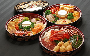 three round red plates with cooked foods
