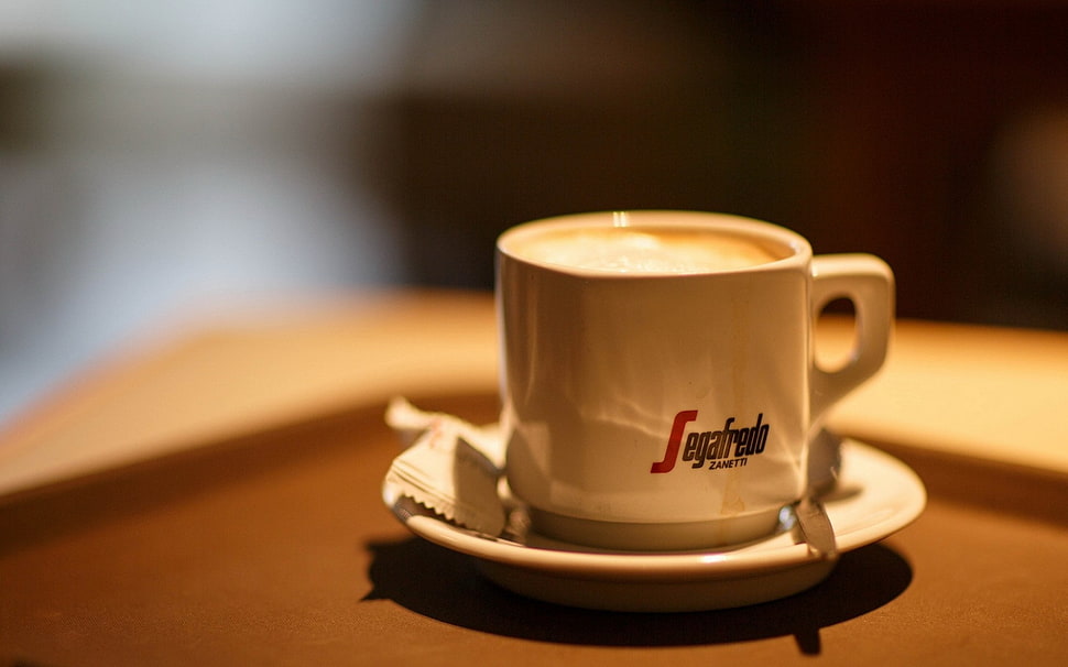 shallow focus photography of white ceramic coffee cup beside spoon and sachet on white ceramic saucer HD wallpaper