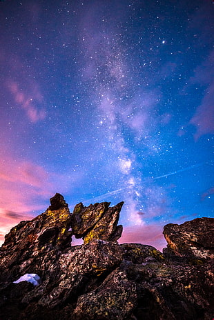 low angle photography of milky way and rocks