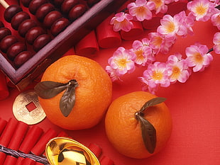 two orange fruits and pink flowers
