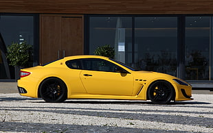 yellow coupe near brown building HD wallpaper