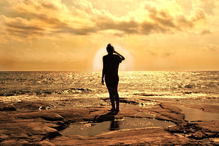 silhouette of person standing on seashore HD wallpaper
