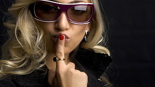 woman wearing oversized sunglasses and gold-colored ring in her index finger