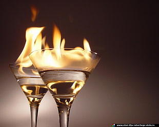 two clear margarita glasses, fire