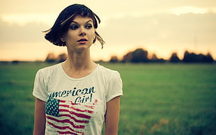 woman wearing white crew-neck shirt with American Girl print