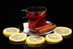 tea on clear glass cup surrounded by lemons