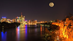 city during at night with full moon HD wallpaper