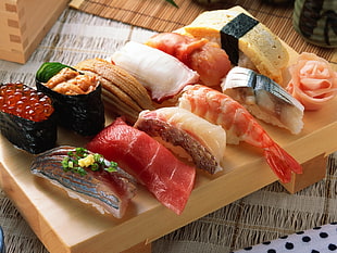 photo of assorted Sushi and maki on brown wooden sushi plate