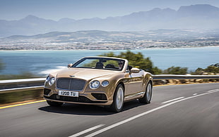 time lapse photo of gold Bentley continental on road